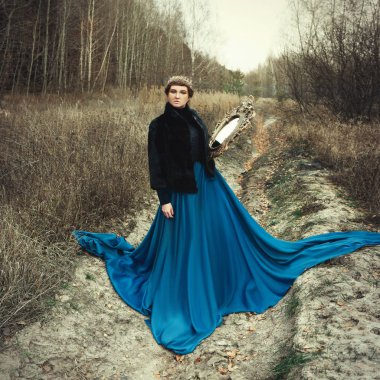Mavi etek giyen modeli bir kraliçe gibi poz