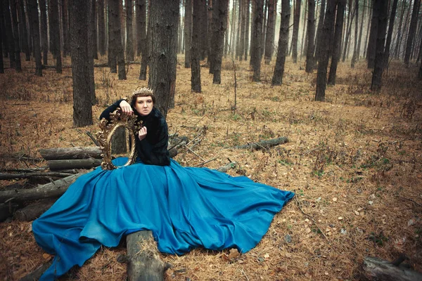 Mavi etek giyen modeli bir kraliçe gibi poz