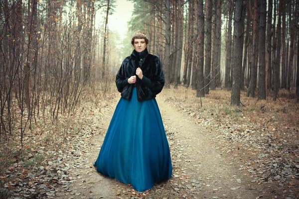 Mavi etek giyen modeli bir kraliçe gibi poz