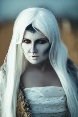 Yaratıcı bir makyaj ile buzlu bir göl kenarında model poz