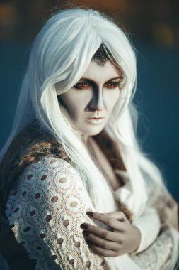 Yaratıcı bir makyaj ile buzlu bir göl kenarında model poz