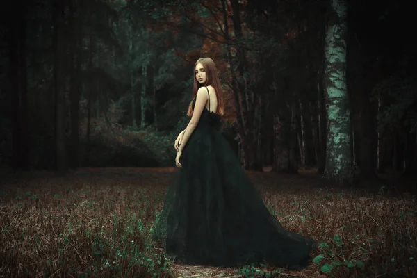 少女は暗い森の黒のドレスを着てポーズをとってください — ストック写真