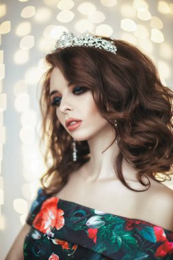 İç bir stüdyoda bir peri masalı uzun elbise ve bir taç giyen genç model poz