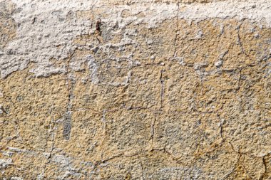 Eski beton duvarın arka planı ve dokusu üzerinde çatlak boya var.
