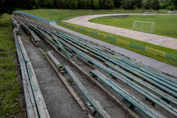 Bancos vazios para espectadores no antigo estádio abandonado — Fotografia de Stock