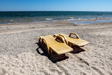 Güzel deniz manzarası ve turistleri bekleyen güneşli yataklar.
