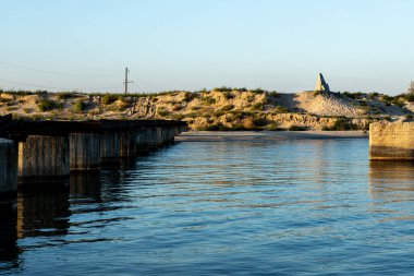 Bir kıyıdan diğerine bir köprüye karşı dar deniz ve kalıntıları.
