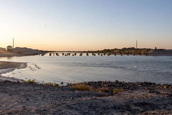 Bir kıyıdan diğerine bir köprüye karşı dar deniz ve kalıntıları.