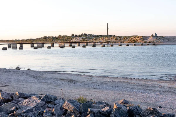 Bir kıyıdan diğerine bir köprüye karşı dar deniz ve kalıntıları.