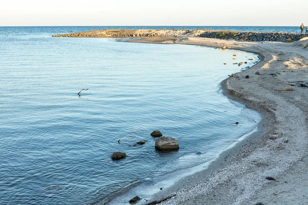 Кам'яний і піщаний берег з хвилями під час заходу сонця — стокове фото