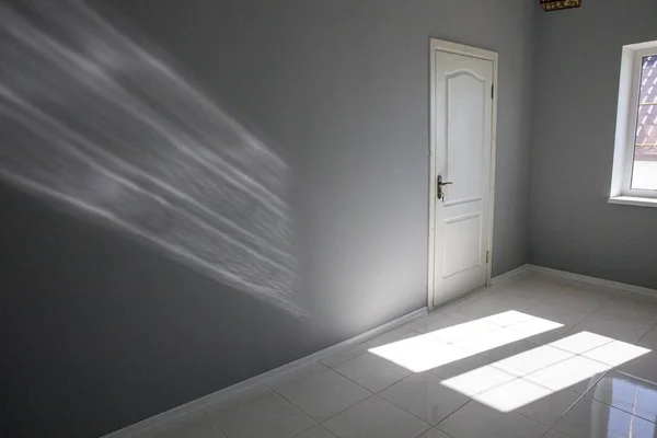 Pintu, jendela dan titik cahaya di ruang kosong abu-abu. Rumah baru tanpa perabotan. — Stok Foto
