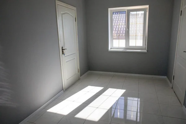 Pintu, jendela dan titik cahaya di ruang kosong abu-abu. Rumah baru tanpa perabotan. — Stok Foto