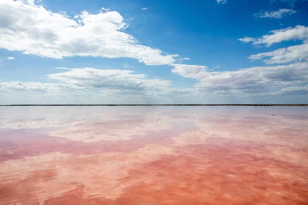 Un bellissimo lago salato rosa con nuvole che si riflettono in esso. Panorama favoloso — Foto Stock