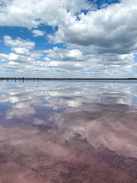 Un bellissimo lago salato rosa con nuvole che si riflettono in esso. Panorama favoloso — Foto Stock