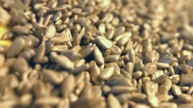 Kabuklu Ayçekirdeği sarı bir arka plan üzerinde. 2 tekila. Yakın çekim. Yatay pan. 1. ayçiçek haddeleme aşağı (soldan sağa) sarı bir arka plan üzerinde tohum ve uzay frame.2 doldurur. Yatay (sağdan sola) yavaş pan.