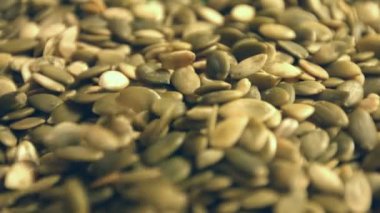 Kabak Çekirdeği kabuklu. Ağır çekim. Yakın çekim. Yatay ve dikey pan. 2 Shots.1. Kabak çekirdeği yere düşüp alanı çerçeve doldurun. Yatay (sağdan sola) yavaş pan. 2. dikey (yukarıdan aşağıya) yavaş pan.