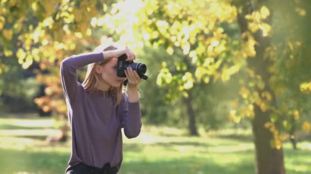 blesser fille et écureuil dans le parc. 2 tirs. 1. Fille se tient avec appareil photo dans le parc. Elle prend des photos de la nature. 2. L'écureuil court dans le fond. Le vent souffle le soleil brille .