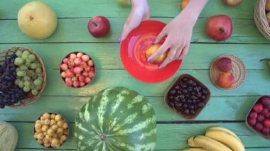 Meyve yeşil ekolojik arka plan üzerinde. Üstten görünüm. Çeşitli meyve arabirim ahşap arka plan üzerinde yer alır. Kadınların elleri üzüm ve nektarin Eko tablosundan alır. Buradasınız: kiraz, muz, armut, Erik, karpuz, elma, pomelo, greyfurt.