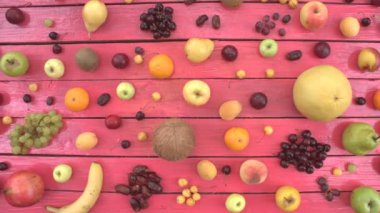 Meyve pembe ekolojik arka plan üzerinde. Üstten görünüm. Çeşitli meyve pembe ahşap Eko arka plan üzerinde yer alır. Erkekler ellerini pomelo tablosundan alır. Buradasınız: pomelo, kiraz, elma, şeftali, tarihi meyve, muz, nektarin, limon, armut, Hindistan cevizi, Erik.