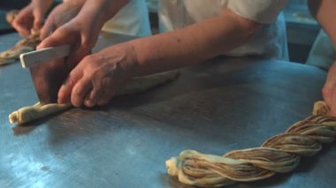 Pasta şefleri pişirme çanağı hazırlayın. Üç şekerci işçileri özel bir tabloda hamur işleri yapmak. Tarçın rulo yapmak için hamur dışarı rulo. (Sağdan sol ve arka) yatay pan.