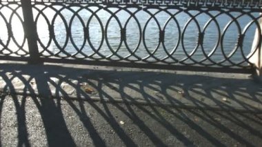 Sonbahar köprüde. Kuru yaprakları kaldırıma. Kız modeli görünüm köprüde duruyor ve sıcak çay içiyor. O harika görünüyor ve bir şey hakkında rüyalar. Şehir hayatı ve arka planda binalar.