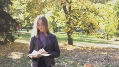 Parktaki kızlar. Parktaki çimlere oturup gülerler. Onlar parkta havanın tadını çıkarırlar. İnsanlar arka planda yürür. Pozitif ruh hali. Öğrenci yaşıyor..