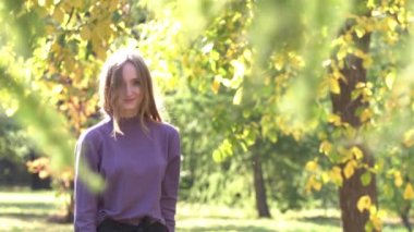 Park kız. Neşeli kız incelikle parkta taşır. Saçında Rüzgar sensually yüzüne düşen geliştirir. Nazik göz kameraya gönderdi. Güneş parlıyor.