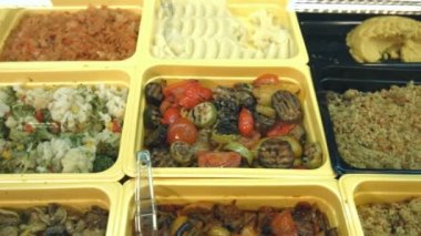 Yan yemekler süpermarkette. Farklı yan yemekler vitrinde yer alan: haşlanmış sebze, sote pilav, ızgara sebze, Avrupa pilav, mantar, lahana, karabuğday, brokoli.