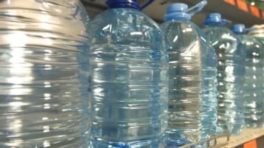 Şişe suyu. Mağaza rafındaki su şişeleri standı.