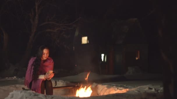 Mulher Nova Com Bebida Quente Pelo Fogo Está Bebendo Bebida — Vídeo de Stock