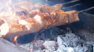 Izgarada barbekü. Clouse yukarı. Cook şişler üzerinde bir taraftan diğer yana et taşır. Eti eşit şekilde kızartıyor. Et pişirme.