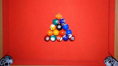 Bilardo. Bilardo topları piramidi itin. Bilardo masasında bilardo topları. Kuvvet ile beyaz top topları piramidi tatili. Kırmızı masa ve çok renkli toplar.
