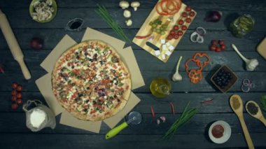 Ekolojik siyah arka planda vejetaryen pizza. Pizza farklı dolgu ile: domates, biber, mantar, çeşitli peynir, zeytin. Yemek pişirmek ve pizza yemek için masada birçok ürün de vardır.