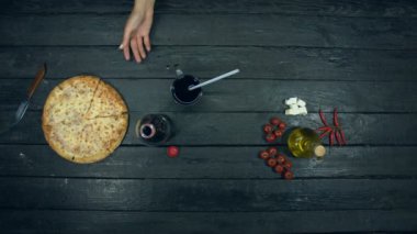 Ekolojik siyah arka planda soda ve peynirli pizza. Kız masadan soda ve pizza parçası alır. Dolgulu peynirli pizza: farklı peynir ve domates. Malzemeler vardır: herry domates, Mozzarella, kırmızı acı biber, ayçiçek yağı.