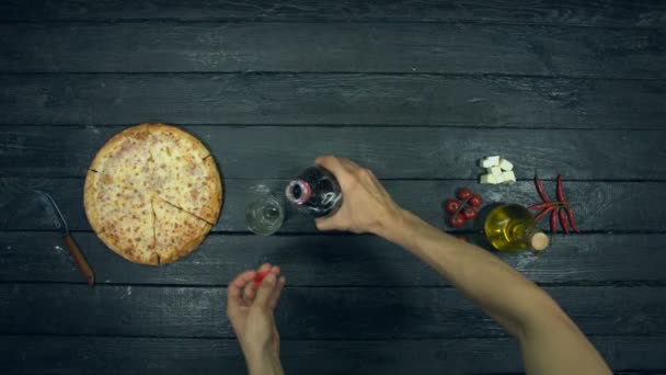 生態学的な黒の背景にソーダとチーズピザ 少年はテーブルからソーダとピザを取る 充填チーズピザ 異なるチーズとトマト 材料があります ヘリートマト モッツァレラ 赤唐辛子 ヒマワリ油 — ストック動画
