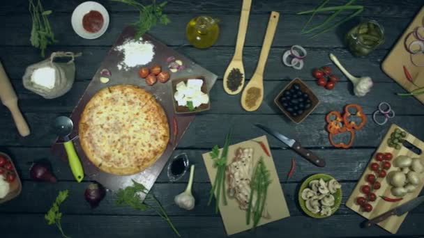 生態学的な黒の背景にチーズピザ チーズピザはエコブラックテーブルの上にあります ピザは 食材で構成されています 異なるシーズ スパイス トマト ピザを調理し 食べるためのテーブルの上に他の多くの製品があります — ストック動画