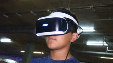 Vr sanal gerçeklik gözlükleri. Çocuk sanal gerçeklik gözlüğü takıyor. O sanal gerçeklik gözlük kullanımı ile oyun oynar ve bir 3d görüntü her şeyi görür. Sanal gerçeklik yeni bir yapay dünya inşa ediyor.