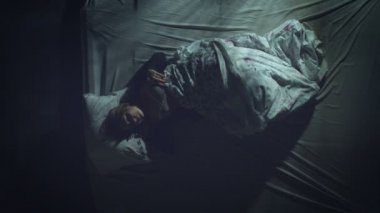 Uyuyan kadın. Huzursuz bir uyku. Süper manzara. Bir kadın yatakta uyur. Bir yandan diğer yana takla atıyor. Pencere önlerinden geçen hafif far üzerine düşüyor..