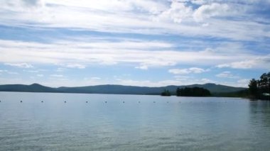 Uzakta bir göl ve yat manzarası. Şehir dışındaki tatil köyünde dinlen. Su güneşte parlar ve parlar..