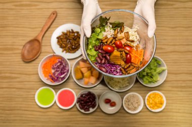 Sebze salatası cam kase - solucan ile sebze salatası böcekler cam kapta tutan insan eller eller. Sağlıklı yemek yüksek protein diyet kavramı. 