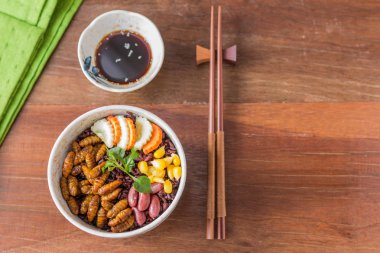 Böcek ve pirinç Berry - kriket böcek, Mısır, kırmızı fasulye, havuç, salatalık bir kasede pirinç Berry ile. Sağlıklı yemek yüksek protein diyet kavramı. Üstten görünüm, seçici odak. 