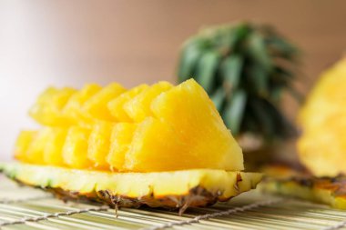Ananas dilimleri ile-taze ananas dilimleri Asya tarzı bambu yer paspaslar arka plan üzerinde. Tropikal meyve kavramı. Seçici odak.