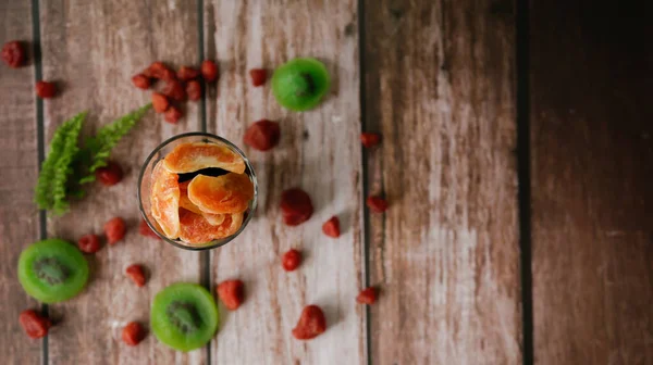 トップビュー 乾燥キウイスライスとガラスの乾燥オレンジ ぼやけた背景のイチゴ 選択的焦点 — ストック写真
