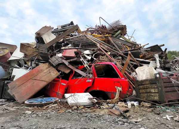 Retro rood voertuig bij de vuilnisbelt. Gebroken staal afval, vintage auto-onderdelen en ijzer in de hoop afval voor recycling. Metaalindustrie van roest schroot - bergingsbedrijf. Recycling Afvalverwijdering. — Stockfoto