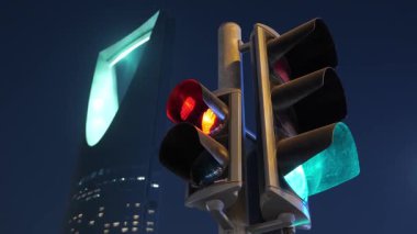 Geceleri Suudi Arabistan, Riyad 'daki Krallık Kulesi' nde trafik ışıkları. Riyad, Suudi Arabistan 'daki trafik ışıklarının gece çekimleri. Arka planda ikonik Krallık Kulesi El Mamlaka Kulesi aydınlanıyor.