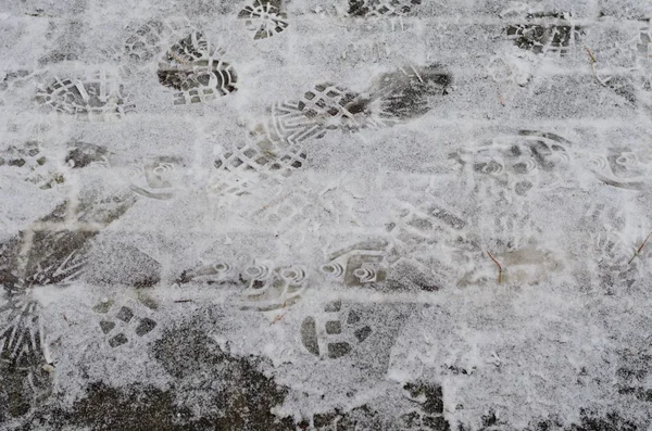 冬の車のタイヤや靴跡の痕跡と雪に覆われた道路 — ストック写真