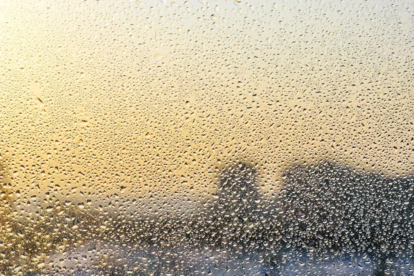 Gotas de chuva e água congelada no fundo de vidro da janela — Fotografia de Stock