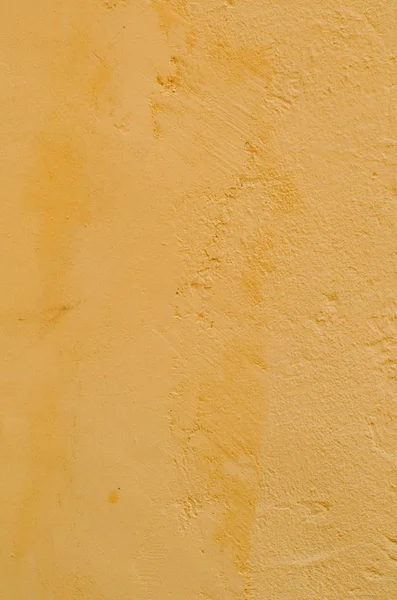 Fondo de un estuco amarillo recubierto y pintado exterior, fundición en bruto de cemento y hormigón textura de la pared, revestimiento decorativo — Foto de Stock
