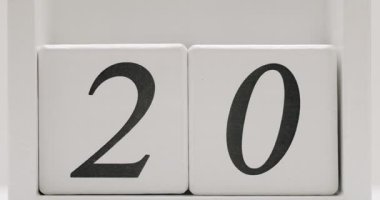 Close-up view of white wooden calendar blocks displaying the number 20, representing a date or countdown. Close-up of Wooden Calendar Blocks Displaying Number 20