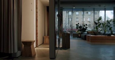 Modern Board Shop Interior with Minimalist Design. Featuring Wooden Furniture, Plants, and Clothing Displays. Natural Light Illuminates the Showroom Floor, Retail, Fashion, and Lifestyle Content.